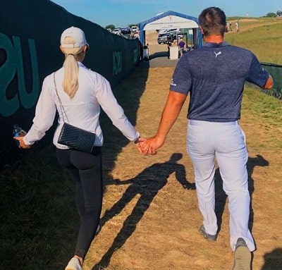Sophia Bertolami and Bryson Dechambeau holding each other's hands