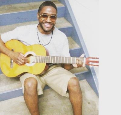 Brandon Bernard playing guitar inside the prison