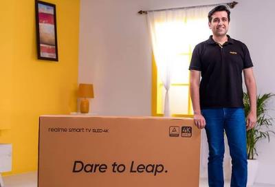 Madhav Sheth standing with a Realme LED TV