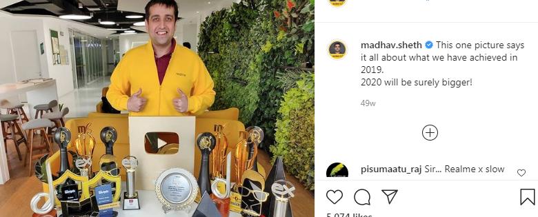 Madhav Sheth standing with all the awards of Realme