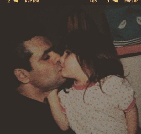 Arienne Mandi kissing her father while being a kid